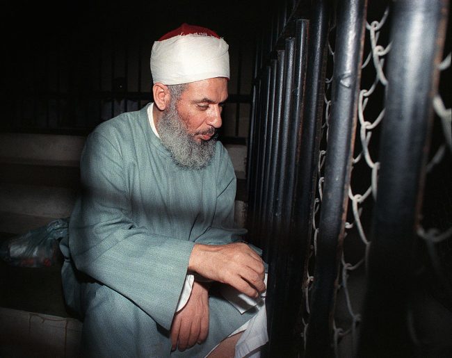 Omar Abdel Rahman sits and prays inside an iron cage at the opening of court session, Aug. 6, 1989 in Cairo. 