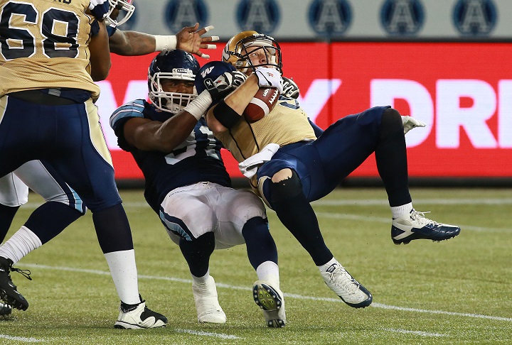 Tristan Okpalaugo sacks former Winnipeg Blue Bombers quarterback Drew Willy during a CFL game at Rogers Centre on Aug. 12, 2014.