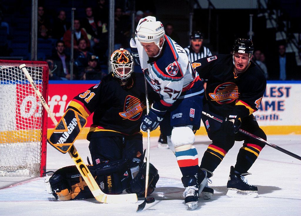 2000 Season: Vancouver goaltender Corey Hirsch thwarts scoring attempt by New York Islander forward Derek King. (Photo by Brian Winkler/Getty Images)
