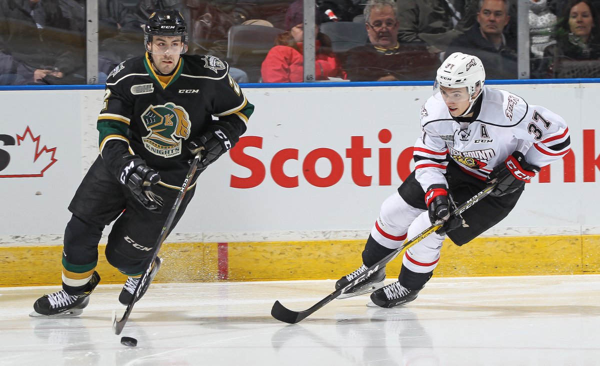 Nick Suzuki of the Owen Sound Attack skates to check Evan Bouchard of the London Knights during a game at Budweiser Gardens on February 3, 2017.