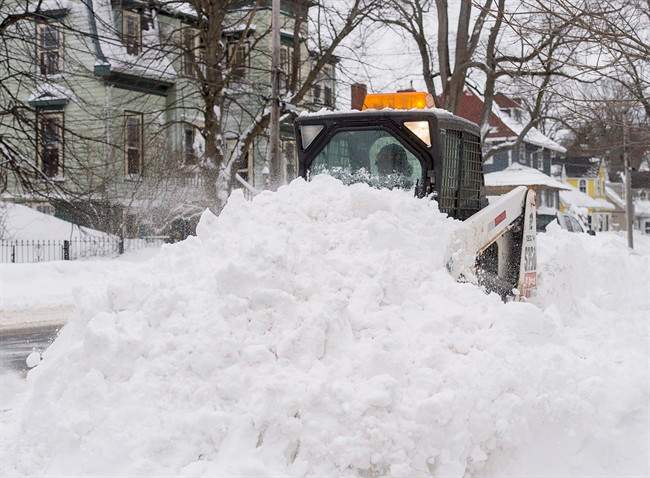 FILE - A sidewalk plow moves snow in Dartmouth, N.S. on Tuesday, Feb. 14, 2017.