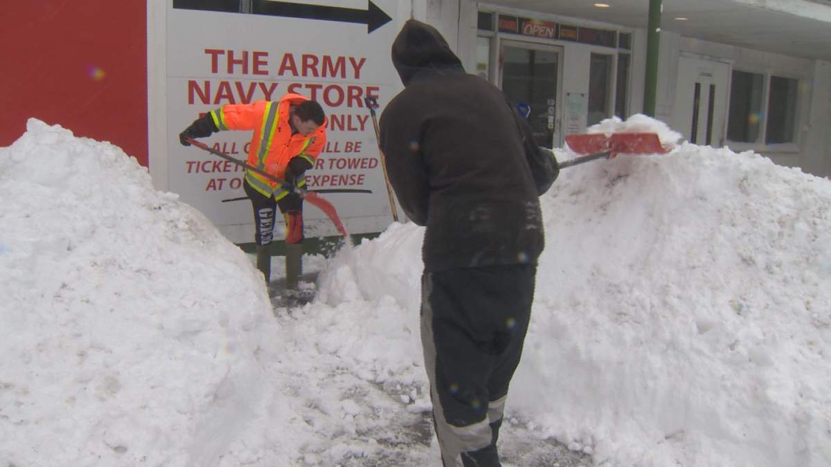 Workers with Hope Property Management work to clear snow from a business in Halifax.