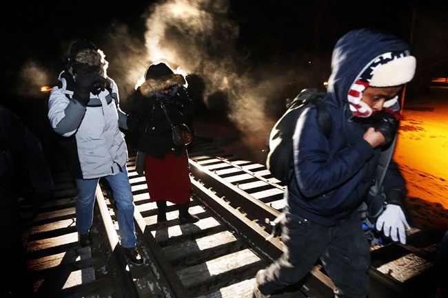 Asylum seekers from Somalia cross into Canada illegally from the United States by walking down a train track into the town of Emerson, Man., early Sunday morning, Feb.26, 2017.