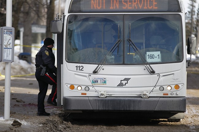 Police search for evidence at the scene of a fatal stabbing of a bus driver at the University of Manitoba in Winnipeg, Tuesday, February 14, 2017.