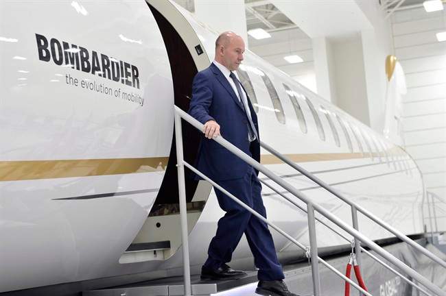 Bombardier CEO Alain Bellemare steps off of a model of a Global 7000 jet before making a press conference in Montreal on Tuesday, February 7, 2017.