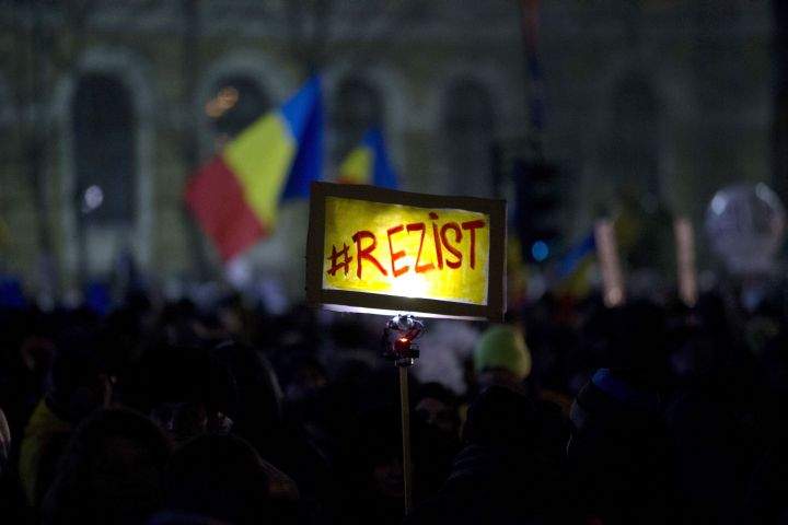 An illuminated banner reading \”Resist\” is carried through the crowd during a demonstration in Bucharest, Romania, Sunday, Feb. 12, 2017. Romania has seen massive protests this month against a government decree that would have diluted the anti-corruption fight that has targeted top officials.