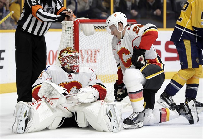 Calgary Flames goalie Brian Elliott (1) and right wing Michael Stone (26) get up off the ice after stopping the puck during the second period of the team's NHL hockey game against the Nashville Predators on Tuesday, Feb. 21, 2017, in Nashville, Tenn.