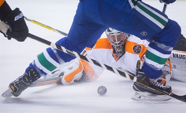Philadelphia Flyers' goalie Michal Neuvirth, back, of the Czech Republic, stops Vancouver Canucks' Brendan Gaunce during the second period of an NHL hockey game in Vancouver, B.C., on Sunday February 19, 2017.