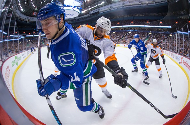 Vancouver Canucks' Reid Boucher, front, is checked by Philadelphia Flyers' Pierre-Edouard Bellemare, of France, during the second period of an NHL hockey game in Vancouver, B.C., on Sunday February 19, 2017. THE CANADIAN PRESS/Darryl Dyck.