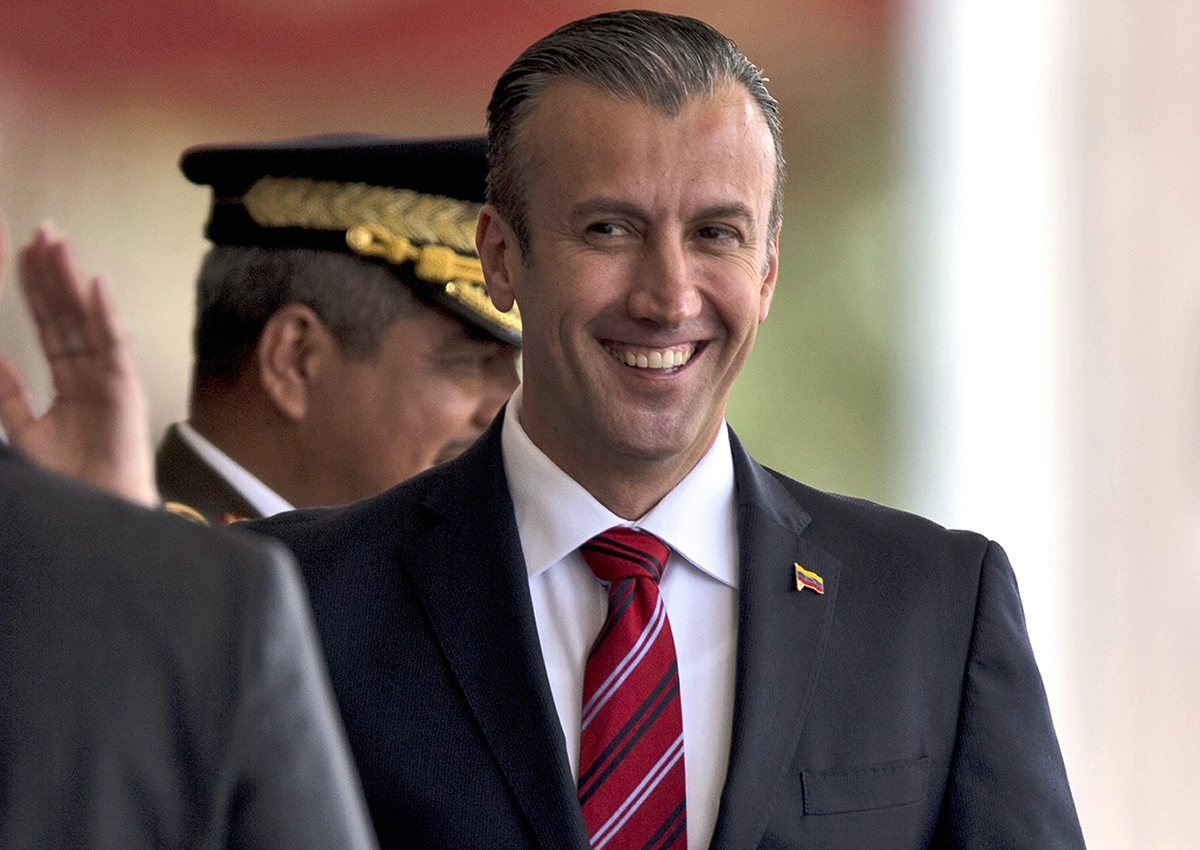 In this Feb. 1, 2017 photo, Venezuela's Vice President Tareck El Aissami, right, is saluted by Boilivarian Army officer upon his arrival for a military parade at Fort Tiuna in Caracas, Venezuela. 
