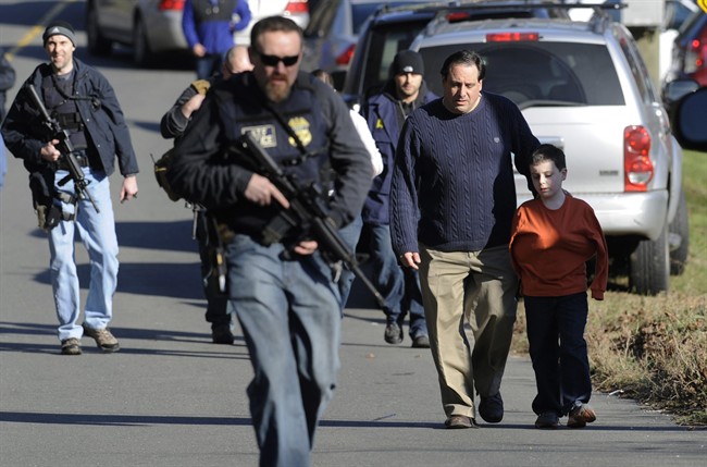 FILE - In this Friday, Dec. 14, 2012 file photo, parents leave a staging area after being reunited with their children following a shooting at the Sandy Hook Elementary School in Newtown, Conn., where Adam Lanza fatally shot 27 people, including 20 children. The Republican-led Senate voted Wednesday, Feb. 15, 2017, to block an Obama-era regulation that would prevent an estimated 75,000 people with mental disorders from being able to purchase a firearm. 
