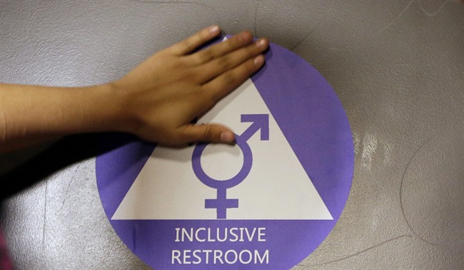 In this May 17, 2016 file photo, a new sticker is placed on the door at the ceremonial opening of a gender neutral bathroom at Nathan Hale High School in Seattle. 