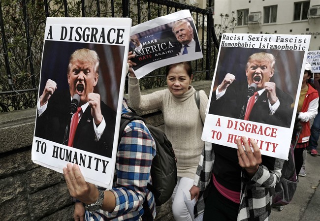 Members of International Migrants Alliance in Hong Kong hold placards during a protest against U.S. President Donald Trump's selective country travel ban outside of the U.S. Consulate in Hong Kong, Sunday, Feb. 5, 2017.