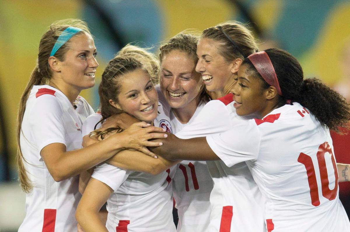 Shelina Zadorsky (left) congratulates Jessie Fleming and her Canadian teammates following a goal at the 2015 Pan Am Games.