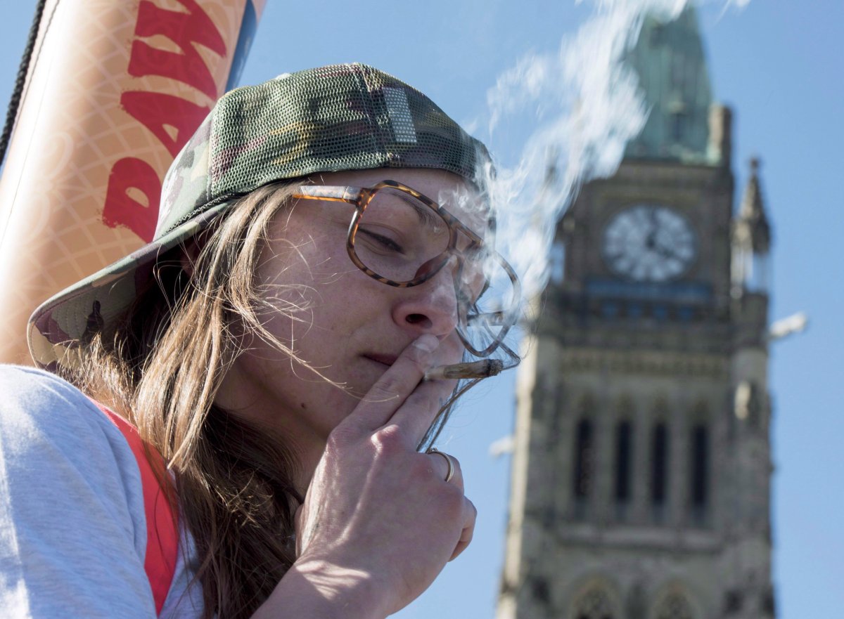 A woman smokes a joint during the 2016 420 marijuana rally on Parliament hill. 