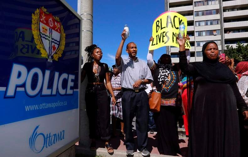 People assemble to honour Abdirahman Abdi in a protest at Ottawa's police headquarters on Saturday, July 30, 2016. Abdi, 37, died following a confrontation with police last Sunday in front of his home in downtown Ottawa. 