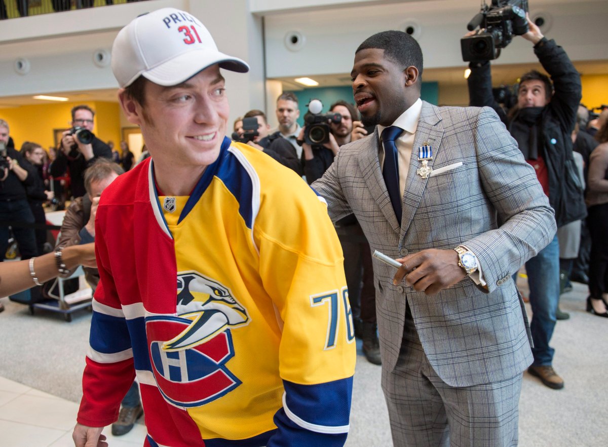 Nashville Predators P.K. Subban signs a split jersey, worn by Pierre-Luc Cantin, showing his present and former team the Montreal Canadiens, during a ceremony, Wednesday, March 1, 2017 in Montreal. Subban received the Governor General Meritorious Service Decoration.