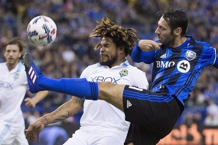 Montreal Impact's Matteo Mancosu, right, challenges Seattle Sounders FC's Roman Torres during first half MLS soccer action in Montreal, Saturday, March 11, 2017. THE CANADIAN PRESS/Graham Hughes