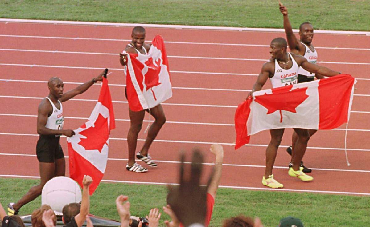 Robert Esmie, Donovan Bailey, Glenroy Gilbert and Bruny Surin, left to right, run their victory lap after winning the Olympic gold medal for the men's 4x100 metre relay at the Summer Olympic Games in Atlanta.August 3, 1996. Fred Chartrand/The Canadian Press