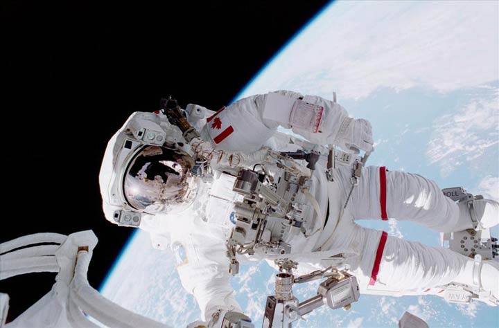 Canadian Space Agency Astronaut Chris Hadfield stands on the portable foot restraint (PFR) connected to Canadarm on Space Shuttle Endeavour during one of two spacewalks.