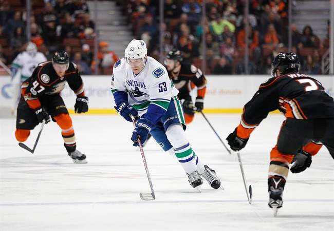 Vancouver Canucks' Bo Horvat, center, skates past Anaheim Ducks' Chris Wagner during the first period of an NHL hockey game, Sunday, March 5, 2017,.