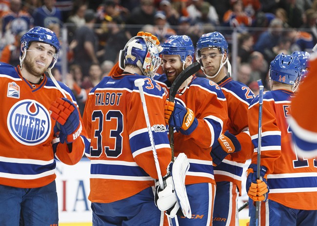 Edmonton Oilers' goalie Cam Talbot (33) is congratulated on a shutout win by teammate Zack Kassian (44) after defeating the Vancouver Canucks 2-0 following third period NHL hockey action in Edmonton on Saturday, March 18, 2017. 