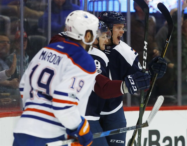 Colorado Avalanche right wing Mikko Rantanen, back, of Finland, celebrates scoring a goal with center Nathan MacKinnon, center, as Edmonton Oilers left wing Patrick Maroon looks on in the first period of an NHL hockey game Thursday, March 23, 2017, in Denver.