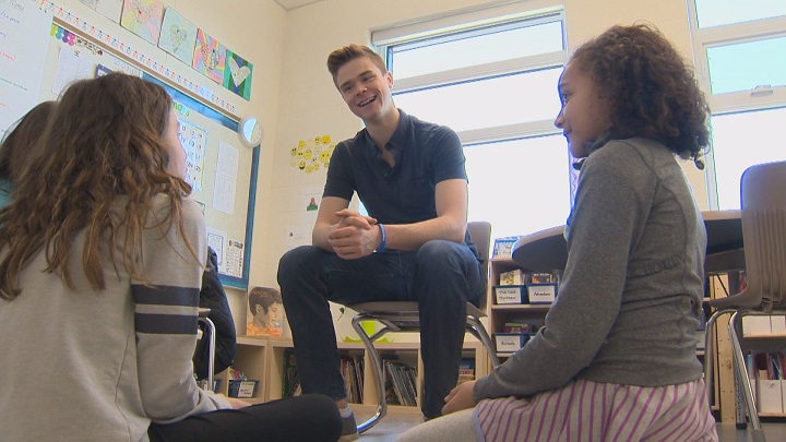 Manitoba Moose goalie Eric Comrie talks to students at  
École Rivière-Rouge about mental health awareness as part of a Project 11 visit.