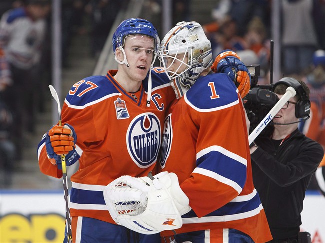Edmonton Oilers' Connor McDavid (97) congratulates goalie Laurent Brossoit (1) on his win during third period NHL action against the Colorado Avalanche, in Edmonton on Saturday, March 25, 2017.