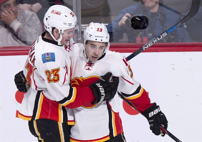 Calgary Flames' Johnny Gaudreau, right, celebrates his goal against the Montreal Canadiens with teammate Sean Monahan during third period NHL hockey action Sunday, March 20, 2016 in Montreal.