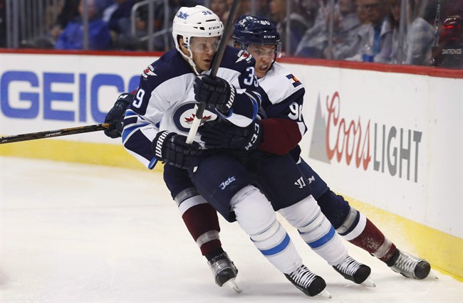 Winnipeg Jets defenceman Toby Enstrom races to the puck with Colorado Avalanche right wing Mikko Rantanen during the third period of an NHL hockey game on Oct. 28, 2016, in Denver.