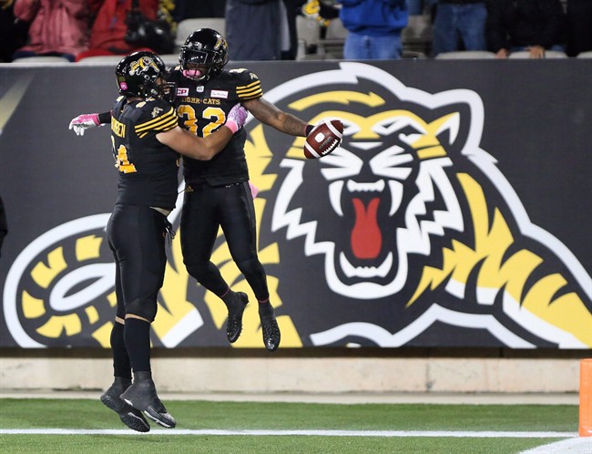 Hamilton Tiger-Cats running back C.J. Gable (32) celebrates his touchdown with Hamilton Tiger-Cats offensive lineman Ryan Bomben (64) during the second-half of CFL football action in Hamilton on Friday, October 14, 2016.