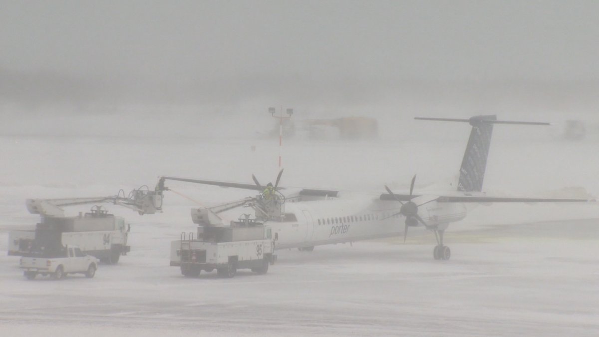 In this file photo, de-icing trucks work on a plane at Halifax Stanfield International Airport. 