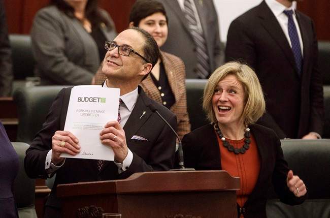 Alberta Finance Minister Joe Ceci hold the budget as Alberta Premier Rachel Notley reacts after tabling the 2017 provincial budget, in Edmonton on Thursday, March 16, 2017. 