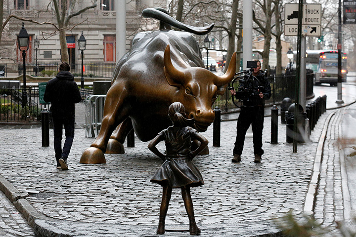 A cameraman films a statue of a girl facing the Wall St. Bull in the financial district in New York, U.S., March 7, 2017. 