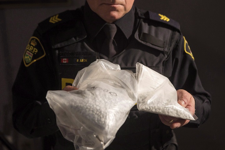 An OPP officer displays bags containing fentanyl as Ontario Provincial Police host a news conference in Vaughan, Ont., on Thursday, February 23, 2017, detailing an investigation into illegal firearms and trafficking of illegal drugs in Ontario, Quebec and the United States. 