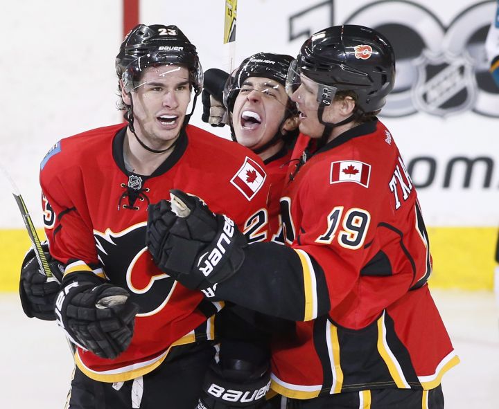 Calgary Flames' Sean Monahan, left, celebrates with Johnny Gaudreau, centre, and Matthew Tkachuk after his goal during second period NHL action against the San Jose Sharks, in Calgary, Alta., Friday, March 31, 2017. 