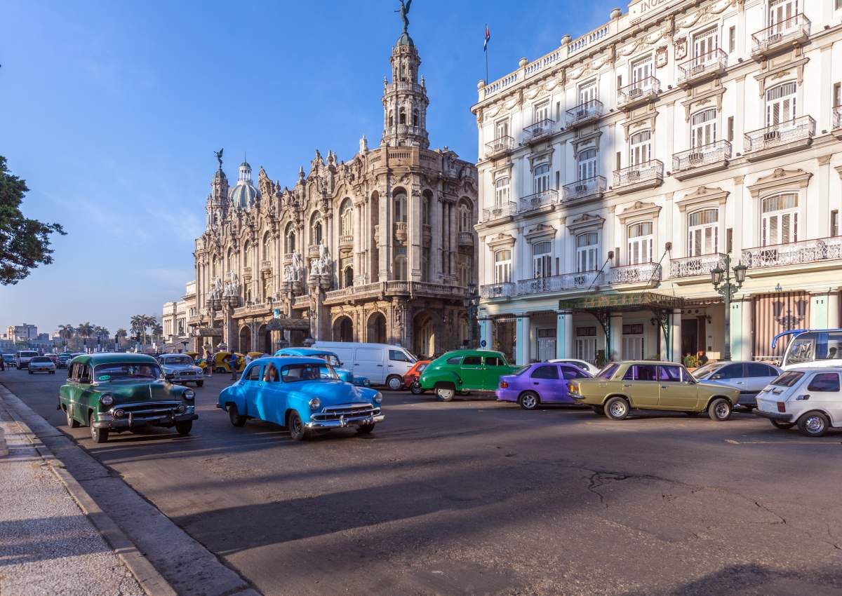 vintage cars driving by the Great Theatre in Havana, Cuba.
