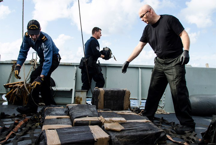 Crew members from Her Majesty’s Canadian Ship Saskatoon load a cargo net with seized illicit drugs to transfer them to a United States Coast Guard ship during Operation Caribbe.