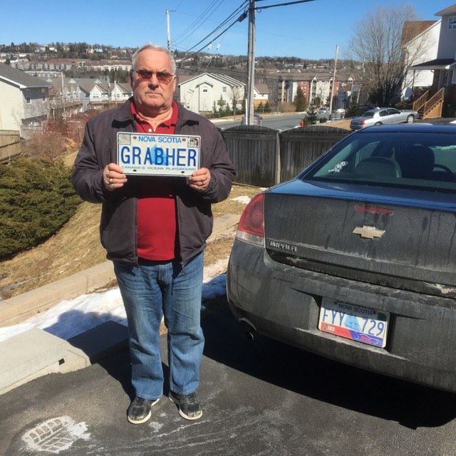 Lorne Grabher holds his cancelled Nova Scotia license plate bearing his family name.