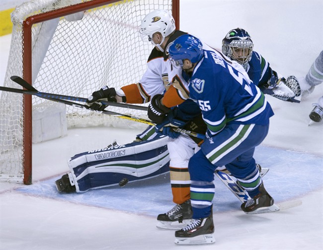 Vancouver Canucks defenceman Alex Biega (55) tries to clear Anaheim Ducks right wing Corey Perry (10) from getting a shot on Vancouver Canucks goalie Ryan Miller (30) during second period NHL action in Vancouver on Tuesday, March 28, 2017. 