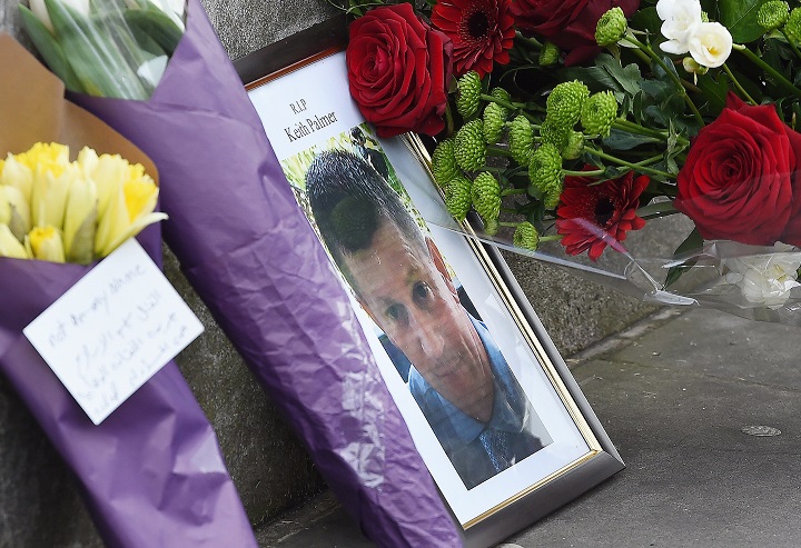 A photograph of policeman Keith Palmer who was killed in the terror attack is placed on Whitehall with flowers in central London. (EPA/ANDY RAIN)