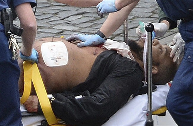 In this March 22, 2017 file photo, the attacker Khalid Masood is treated by emergency services outside the Houses of Parliament London. British Police named on Thursday March 23, 2017, Khalid Masood as The Houses of Parliament attacker. (Stefan Rousseau/PA via AP, File).