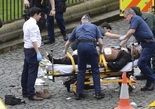 In this March 22, 2017 file photo, the attacker Khalid Masood is treated by emergency services outside the Houses of Parliament London.