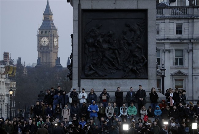 People observe a minute of silence at a vigil for the victims of Wednesday's attack, at Trafalgar Square in London, Thursday, March 23, 2017.