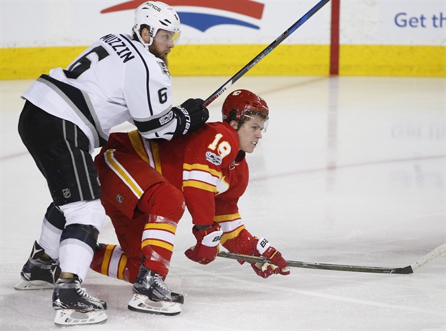 Calgary Flames' Matthew Tkachuk, right, is knocked down by Los Angeles Kings' Jake Muzzin during first period NHL action in Calgary, Alta., Sunday, March 19, 2017. 