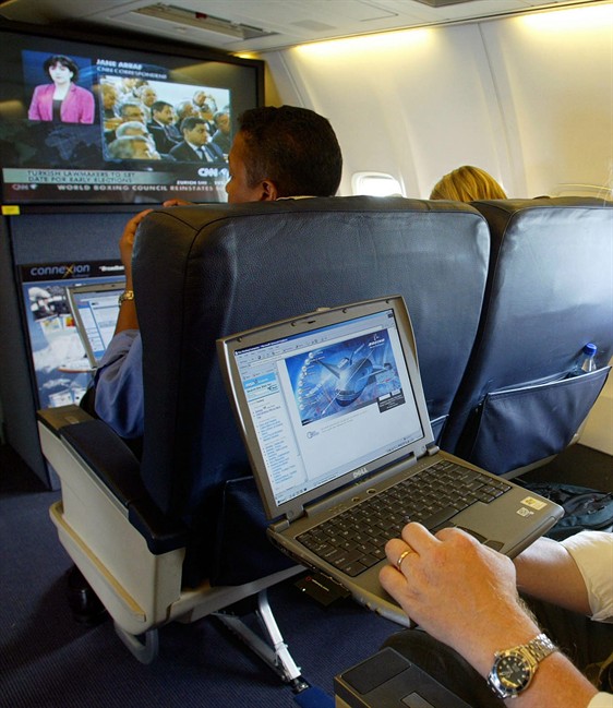 This is a July 29, 2002 file photo of a laptop is used on a plane . Britain's government Tuesday March 21, 2017 banned electronic devices in the carry-on bags of passengers traveling to the U.K. from six countries, following closely on a similar ban imposed by the United States.