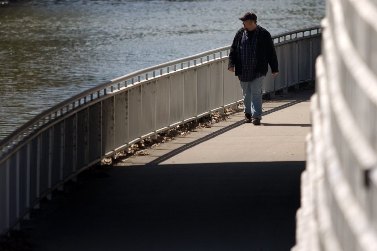 FILE - A man walks along a pathway near the Thames River in London, Ont., April 12, 2012.