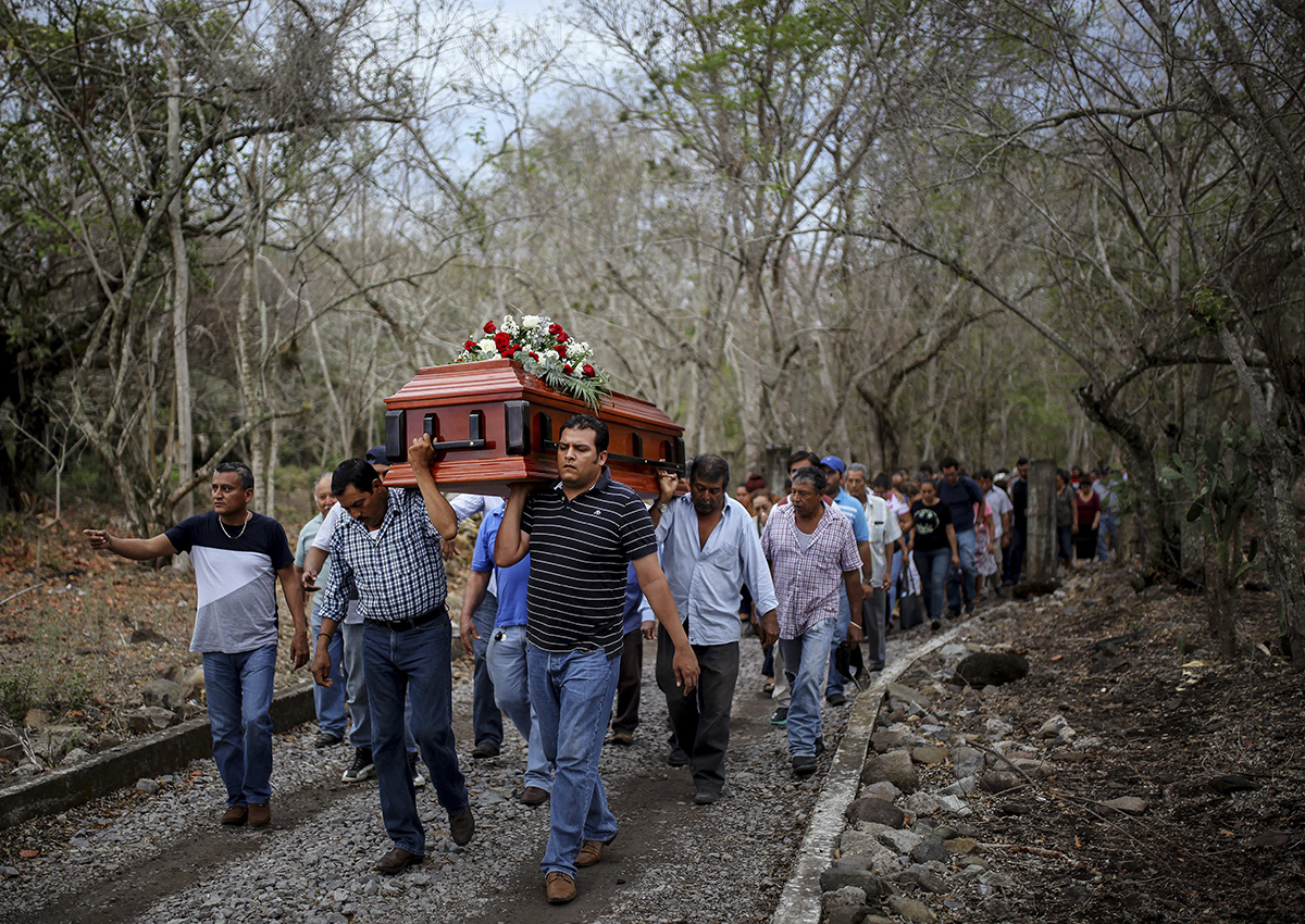 In this March 8, 2017 photo, members of the Solecito search group carry the coffin of Pedro Huesca, a police detective who disappeared in 2013 and was recently found in a mass grave, as they walk to the cemetery in Palmas de Abajo, Veracruz, Mexico.