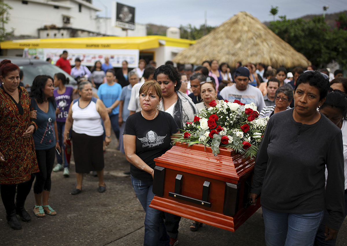 In this March 8, 2017 photo, members of the Solecito search group carry the coffin of Pedro Huesca, a police detective who disappeared in 2013 and was recently found in a mass grave, as they walk to the cemetery in Palmas de Abajo, Veracruz, Mexico.